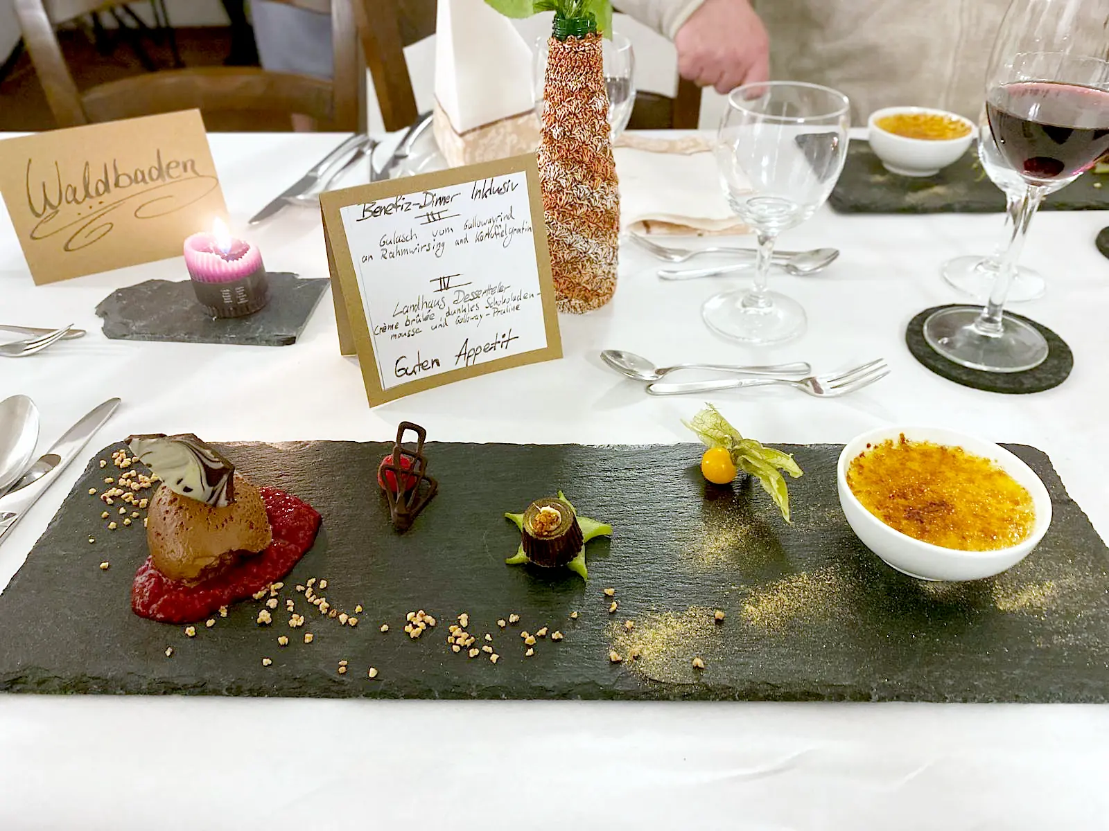 Feierlich gedeckter Tisch mit Deko und brennender Kerze