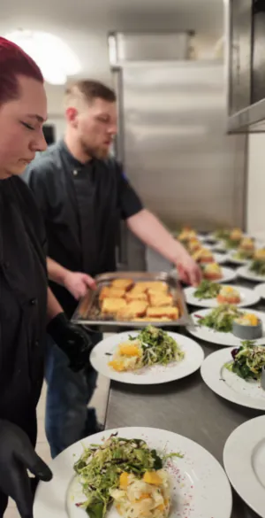 Köchin und Koch beim Anrichten von Speisen